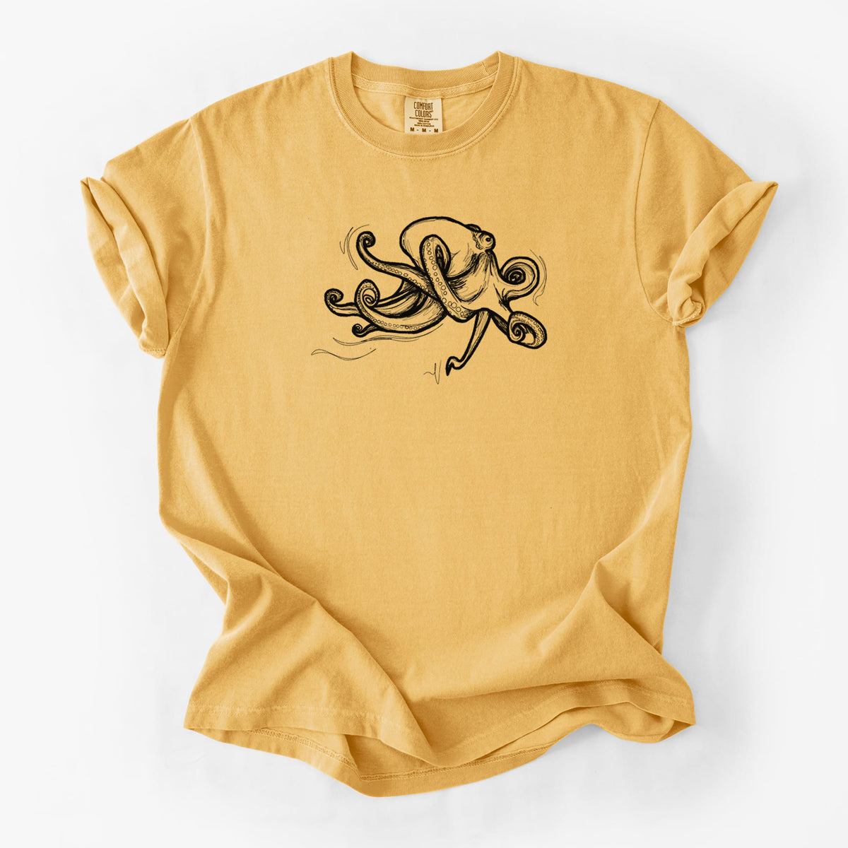 Golden wheat yellow Comfort Colors t-shirt laid flat, printed with a black ink illustration of a giant Pacific octopus with curling tentacles.
