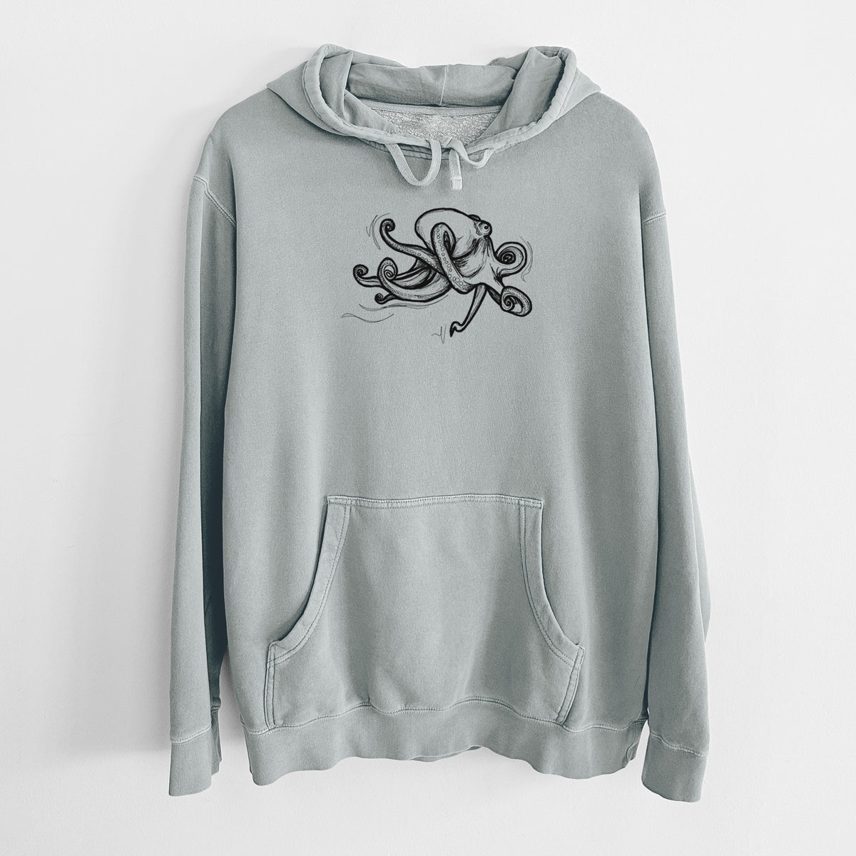 Sage green pigment dyed hoodie laid flat, printed with a black ink illustration of a giant Pacific octopus with curling tentacles.