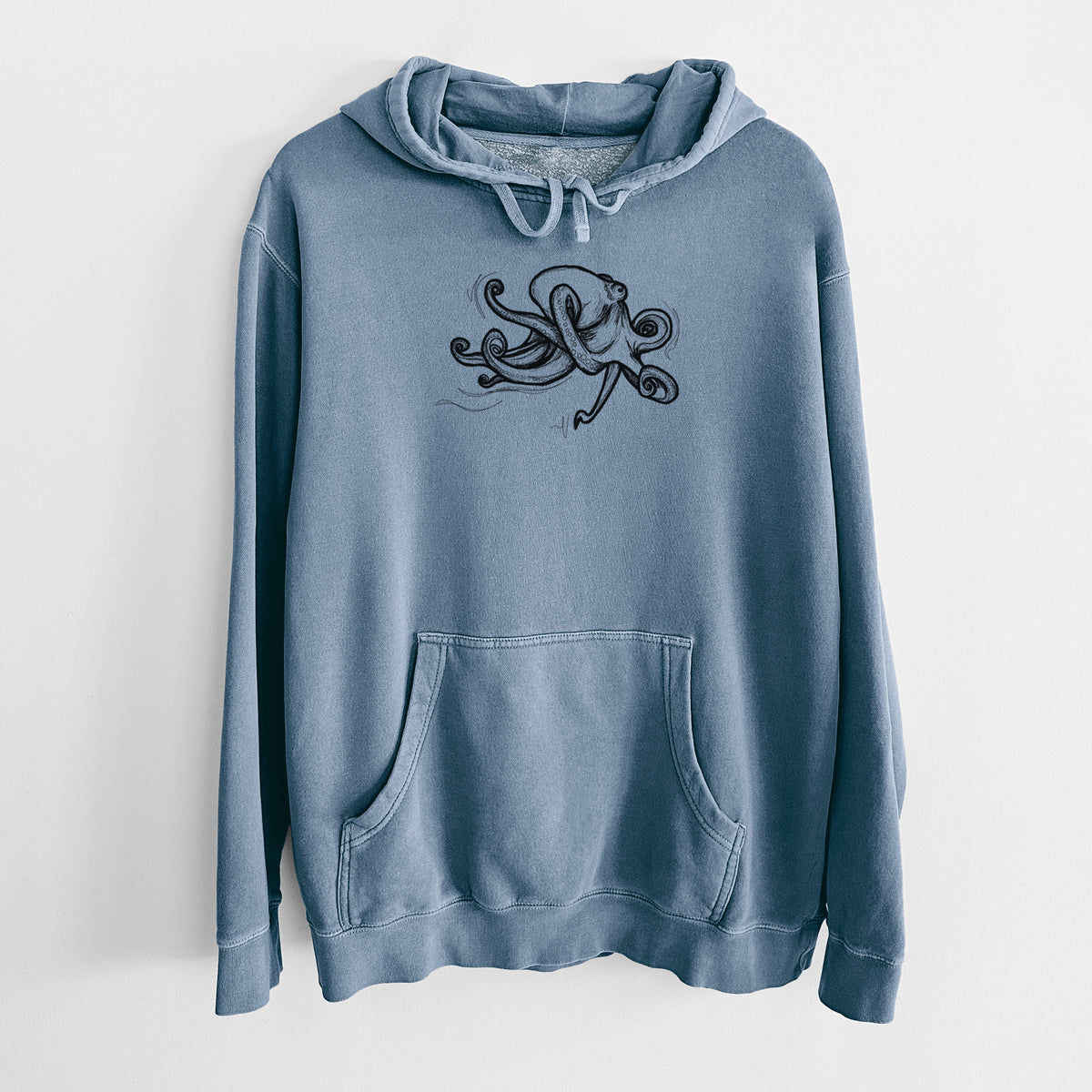 Slate blue pigment dyed hoodie laid flat, printed with a black ink illustration of a giant Pacific octopus with curling tentacles.