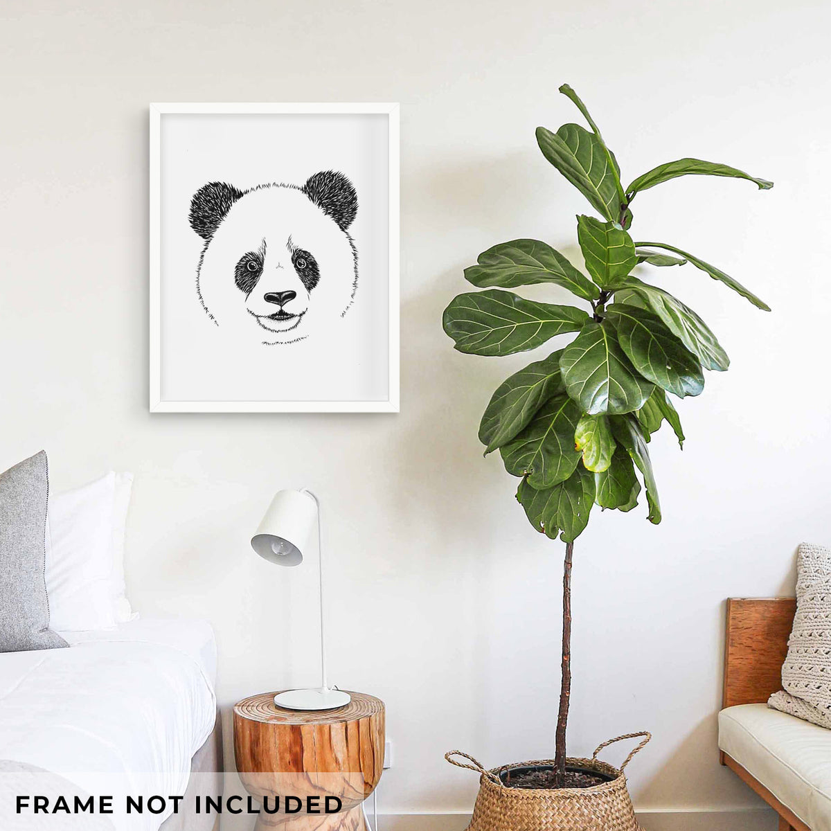 Art print of a black ink portrait of a smiling giant panda's face, shown framed on a living room wall beside a potted plant. Frame not included.