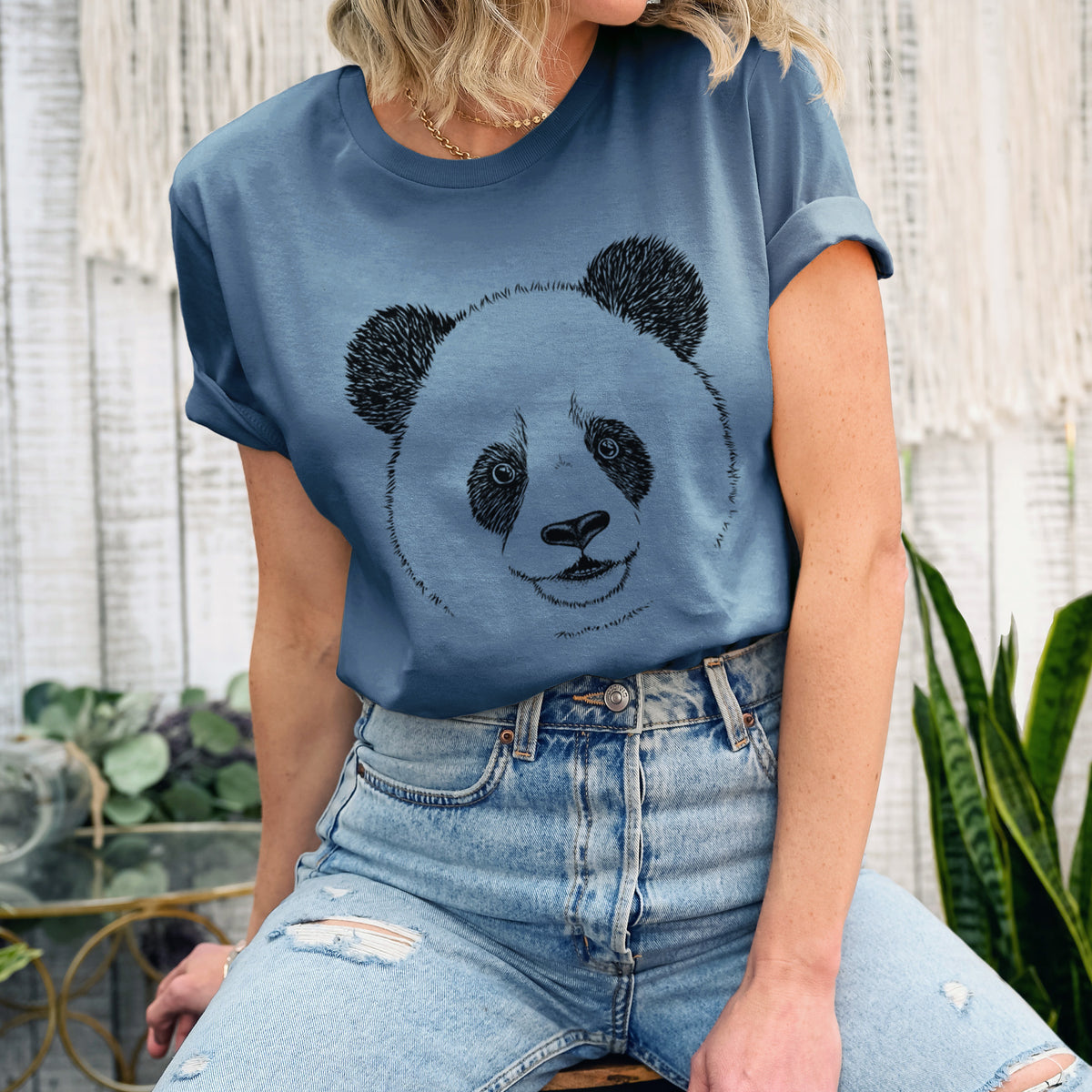 Woman wearing a steel blue lightweight cotton t-shirt printed with a black ink portrait of a smiling giant panda's face.