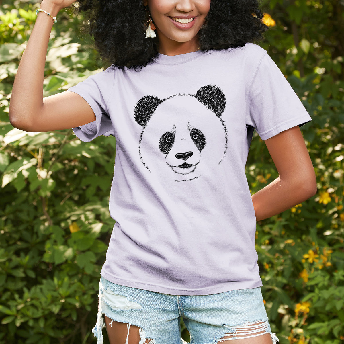 Woman wearing a Comfort Colors t-shirt printed with a black ink portrait of a smiling giant panda's face, outdoors.