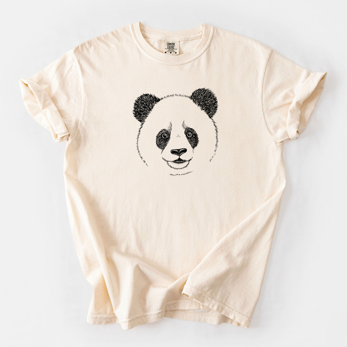 Ivory Comfort Colors t-shirt laid flat, printed with a black ink portrait of a smiling giant panda's face.