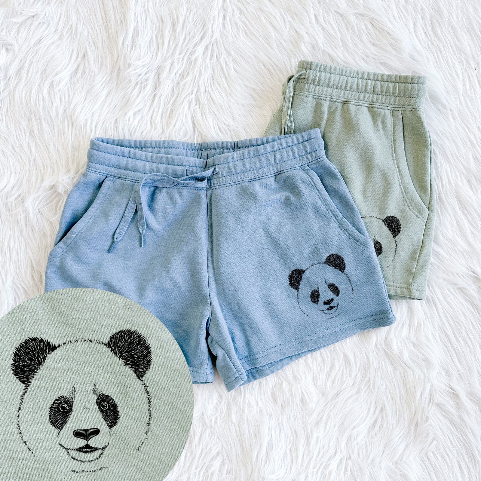 Two pairs of Cali Wave shorts in different colors printed with a black ink portrait of a smiling giant panda's face, with a close-up of the print.