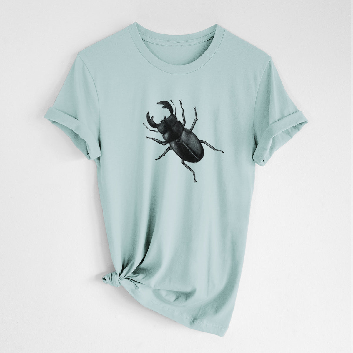 Dusty blue lightweight cotton t-shirt laid flat with the sleeves rolled, printed with a detailed black ink illustration of a giant stag beetle with large jaws, seen from above.
