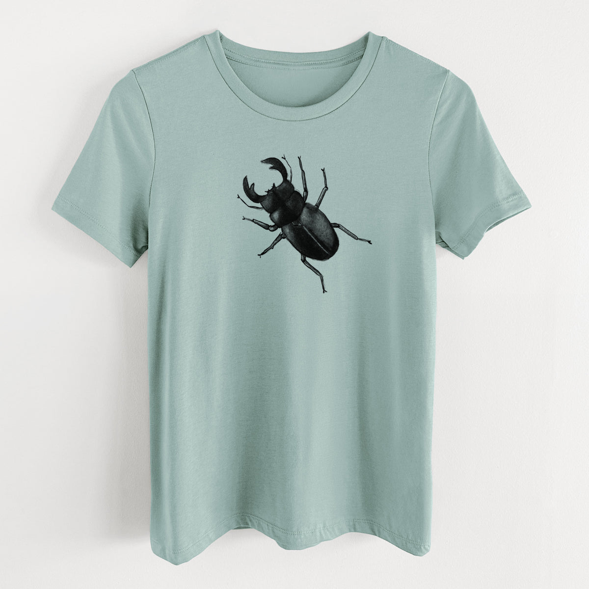 Dusty blue women's relaxed fit cotton t-shirt laid flat, printed with a detailed black ink illustration of a giant stag beetle with large jaws, seen from above.
