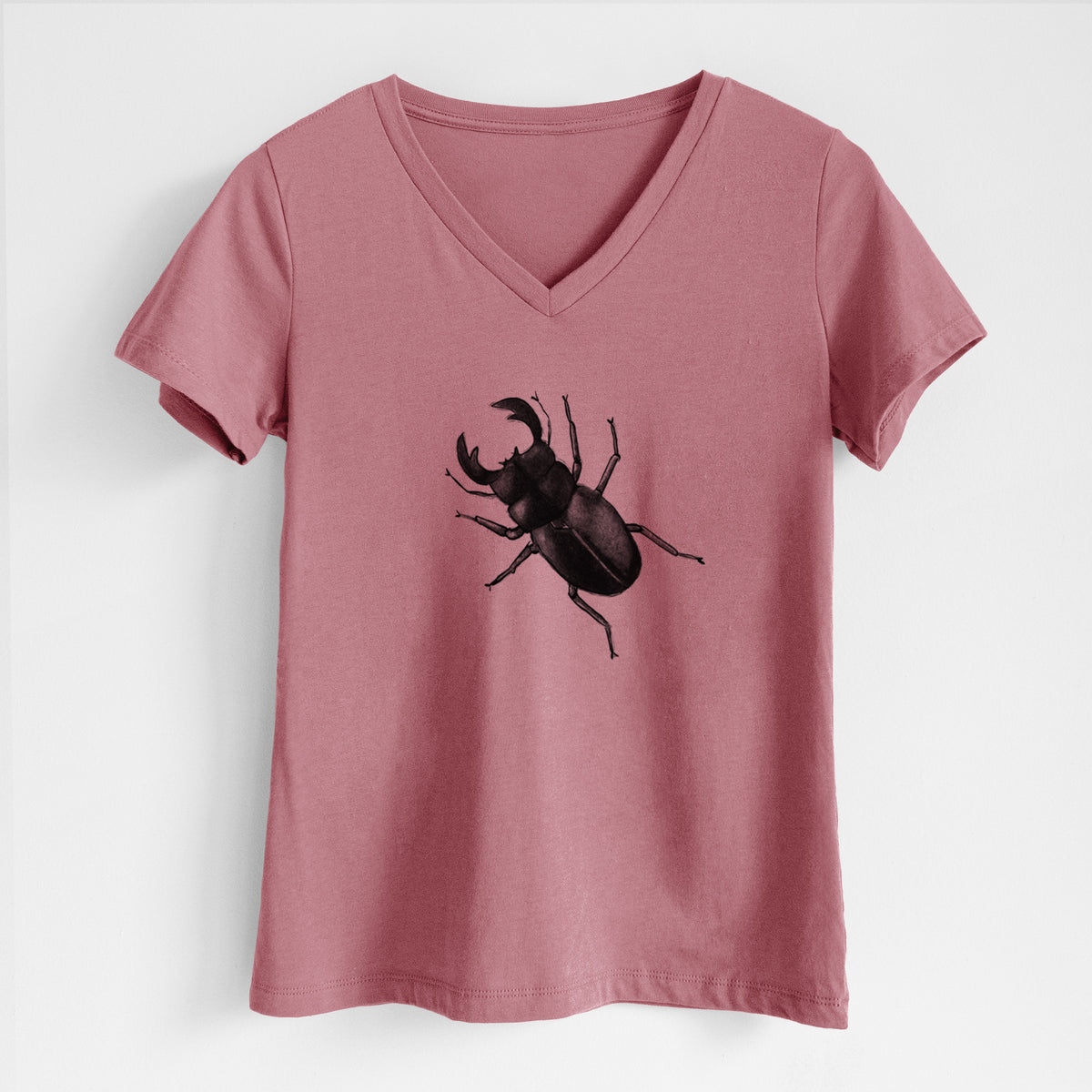 Mauve pink women's relaxed fit cotton V-neck t-shirt laid flat, printed with a detailed black ink illustration of a giant stag beetle with large jaws, seen from above.