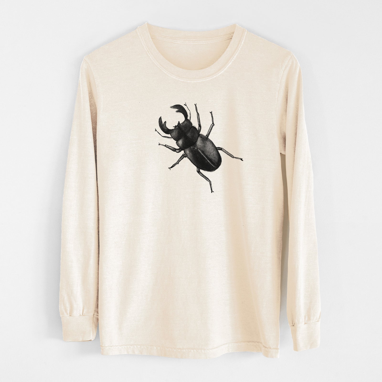 Ivory Comfort Colors long sleeve shirt laid flat, printed with a detailed black ink illustration of a giant stag beetle with large jaws, seen from above.