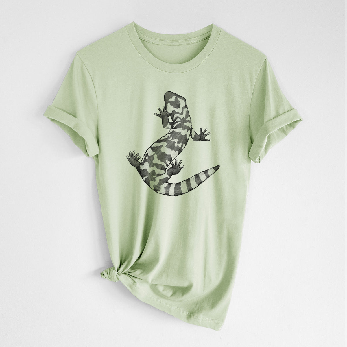 Spring green lightweight cotton t-shirt laid flat with the sleeves rolled, printed with a black ink illustration of a Gila monster with bold patterned skin.