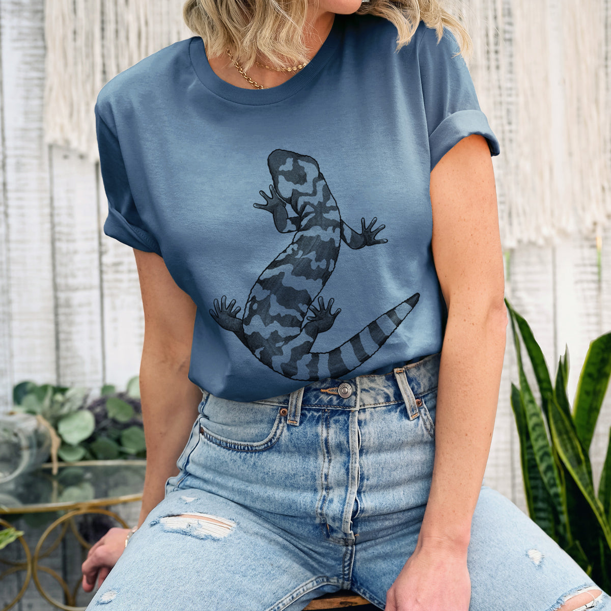 Woman wearing a steel blue lightweight cotton t-shirt printed with a black ink illustration of a Gila monster with bold patterned skin.