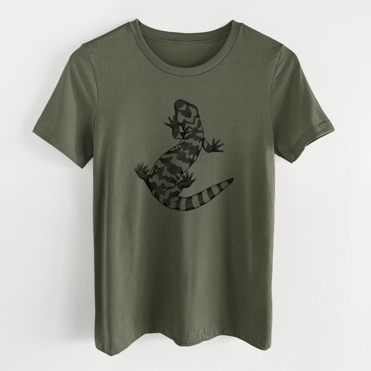 Military green women's relaxed fit cotton t-shirt laid flat, printed with a black ink illustration of a Gila monster with bold patterned skin.