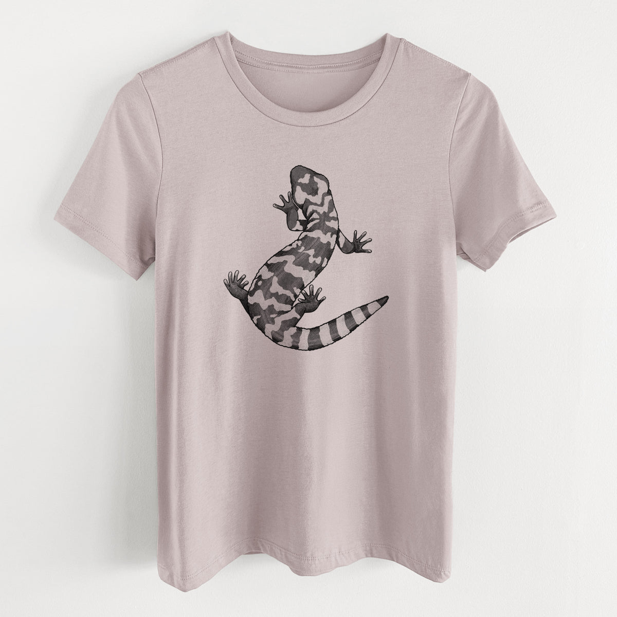 Pink gravel women's relaxed fit cotton t-shirt laid flat, printed with a black ink illustration of a Gila monster with bold patterned skin.