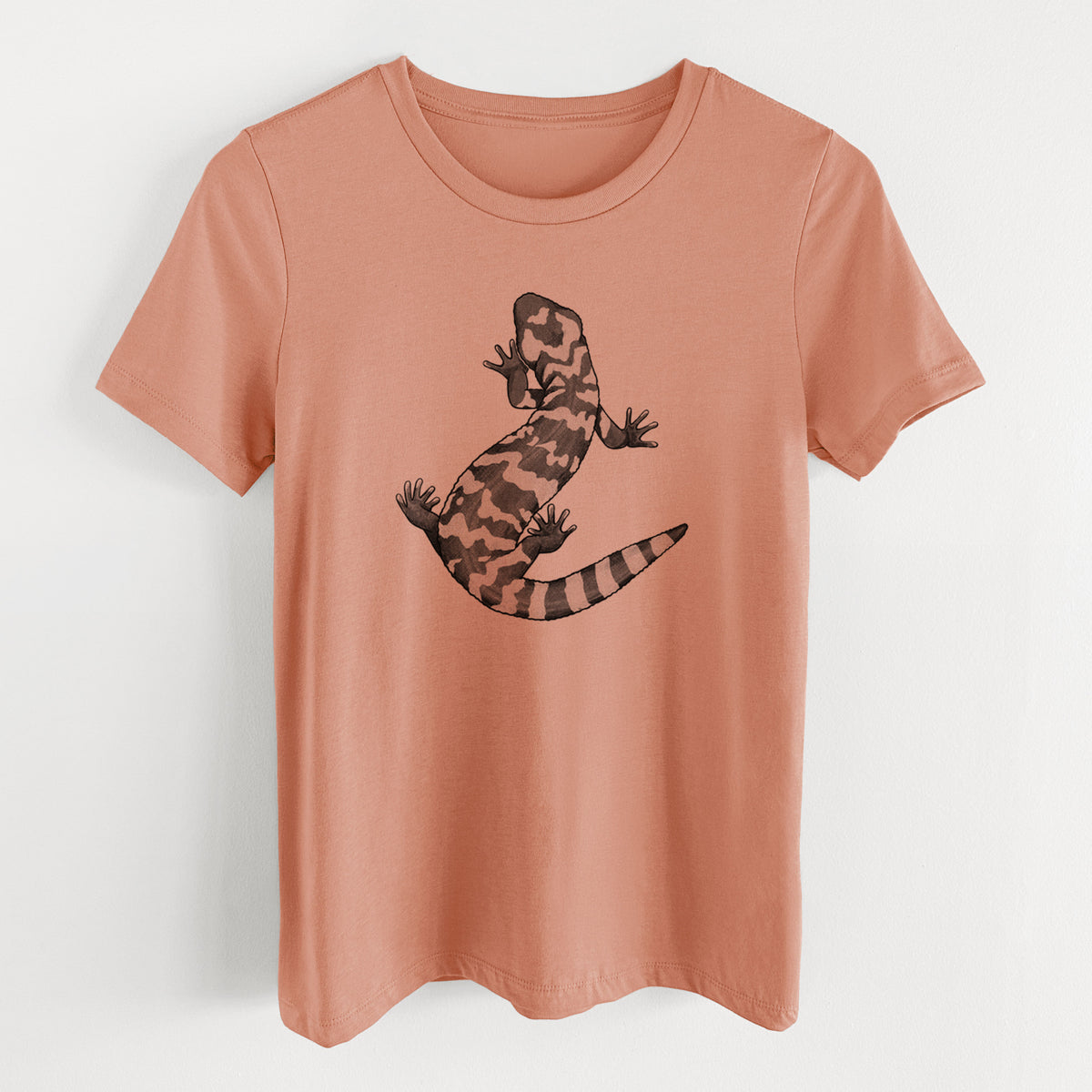 Terracotta orange women's relaxed fit cotton t-shirt laid flat, printed with a black ink illustration of a Gila monster with bold patterned skin.