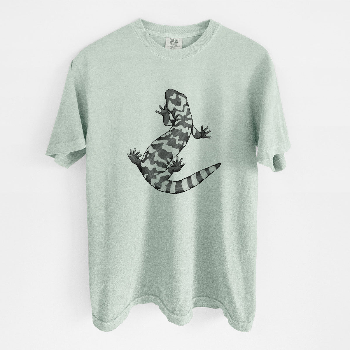 Bay green Comfort Colors t-shirt laid flat, printed with a black ink illustration of a Gila monster with bold patterned skin.