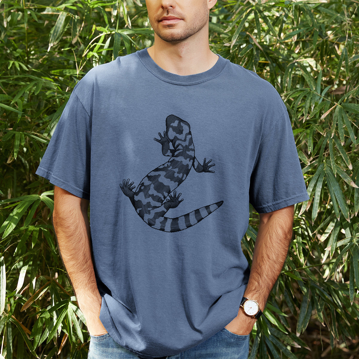 Man wearing a Comfort Colors t-shirt printed with a black ink illustration of a Gila monster with bold patterned skin, outdoors.