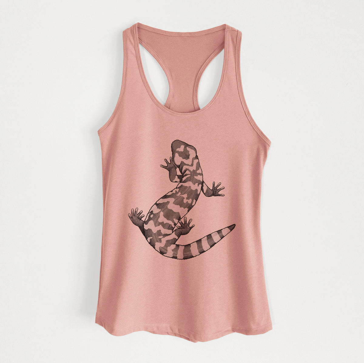 Desert pink women's racerback tank top laid flat, printed with a black ink illustration of a Gila monster with bold patterned skin.
