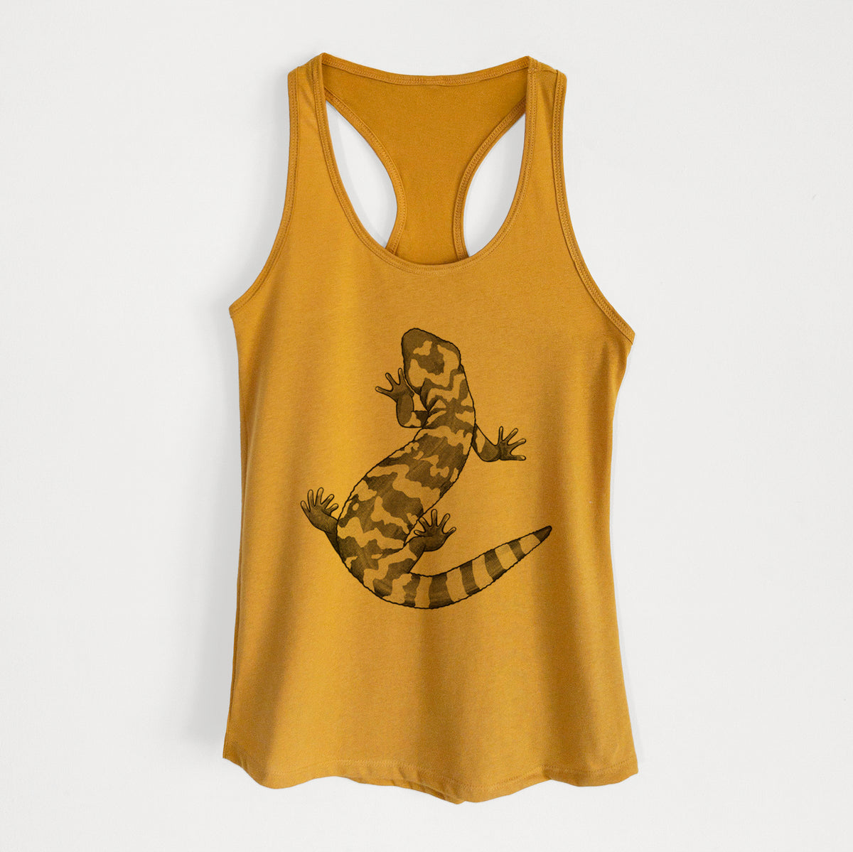 Gold women's racerback tank top laid flat, printed with a black ink illustration of a Gila monster with bold patterned skin.