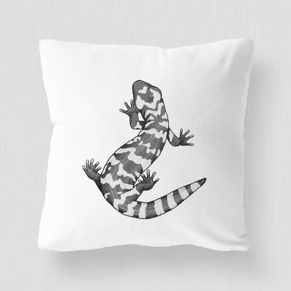 White pillow cover printed with a black ink illustration of a Gila monster with bold patterned skin.