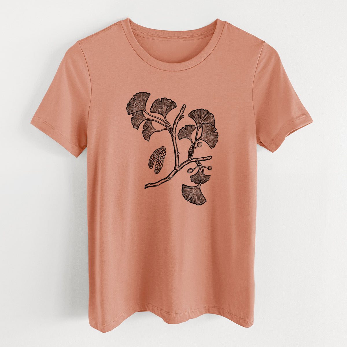 Terracotta orange women's relaxed fit cotton t-shirt laid flat, printed with a black ink illustration of a ginkgo branch with fan-shaped leaves.