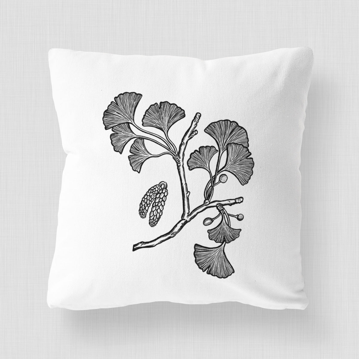 White pillow cover printed with a black ink illustration of a ginkgo branch with fan-shaped leaves.