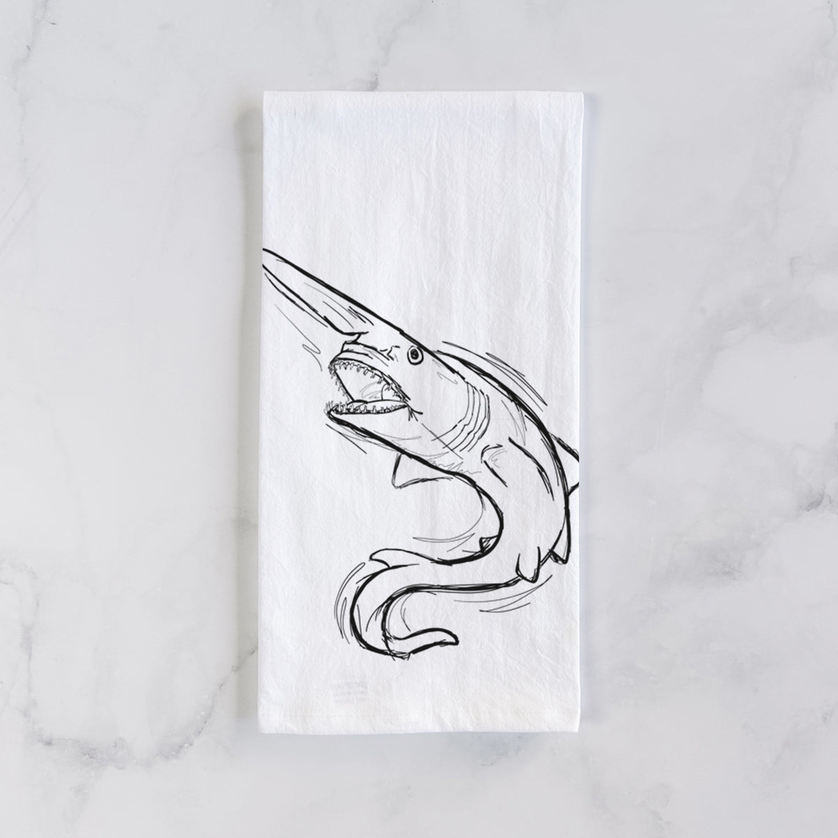 White cotton tea towel laid flat on marble, printed with a black ink illustration of a goblin shark with its long snout, swimming in a curve.