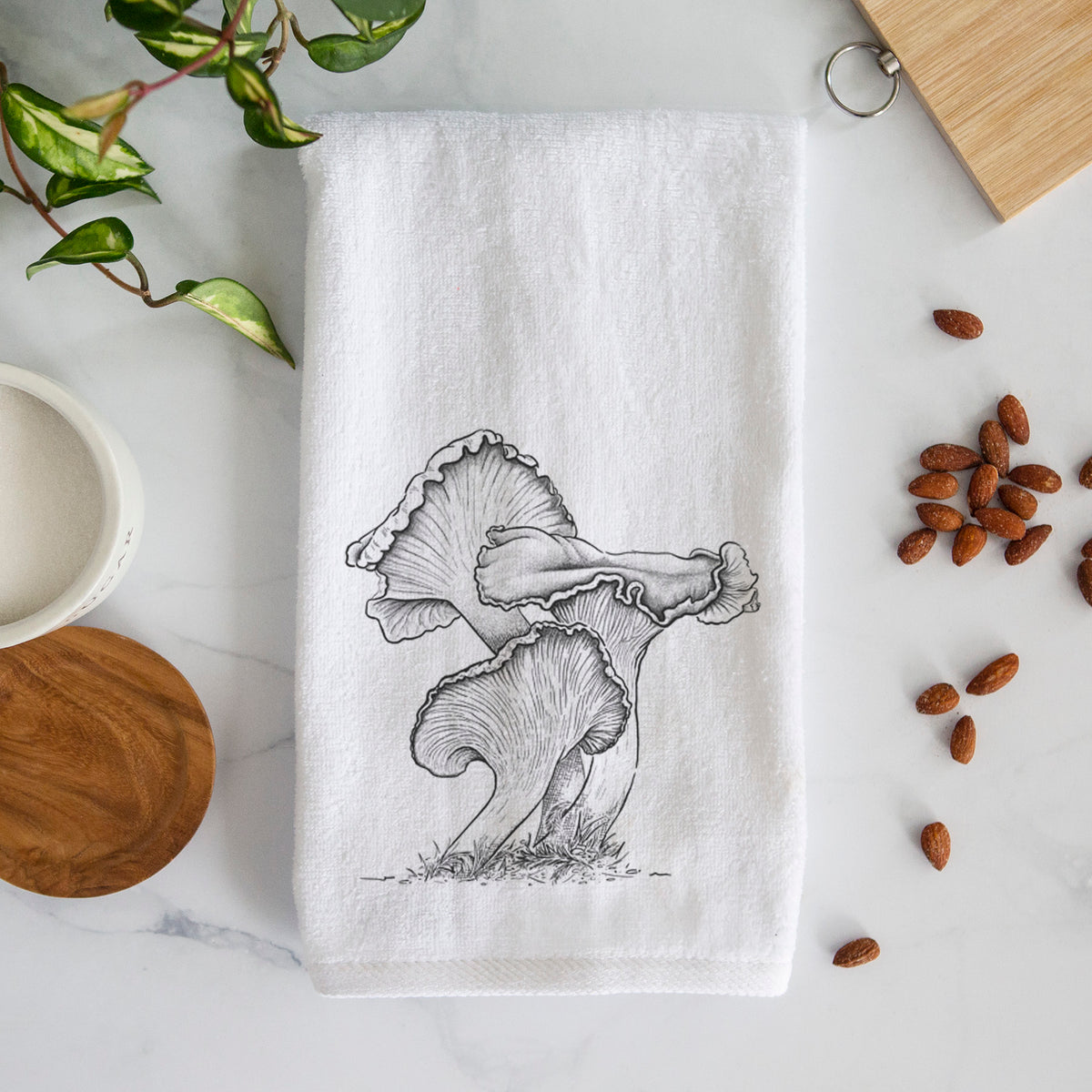 White hand towel printed with a detailed black ink illustration of golden chanterelle mushrooms.
