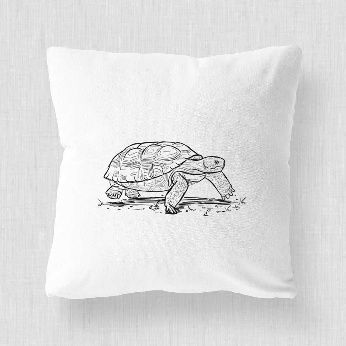 White pillow cover printed with a detailed black ink illustration of a gopher tortoise walking.