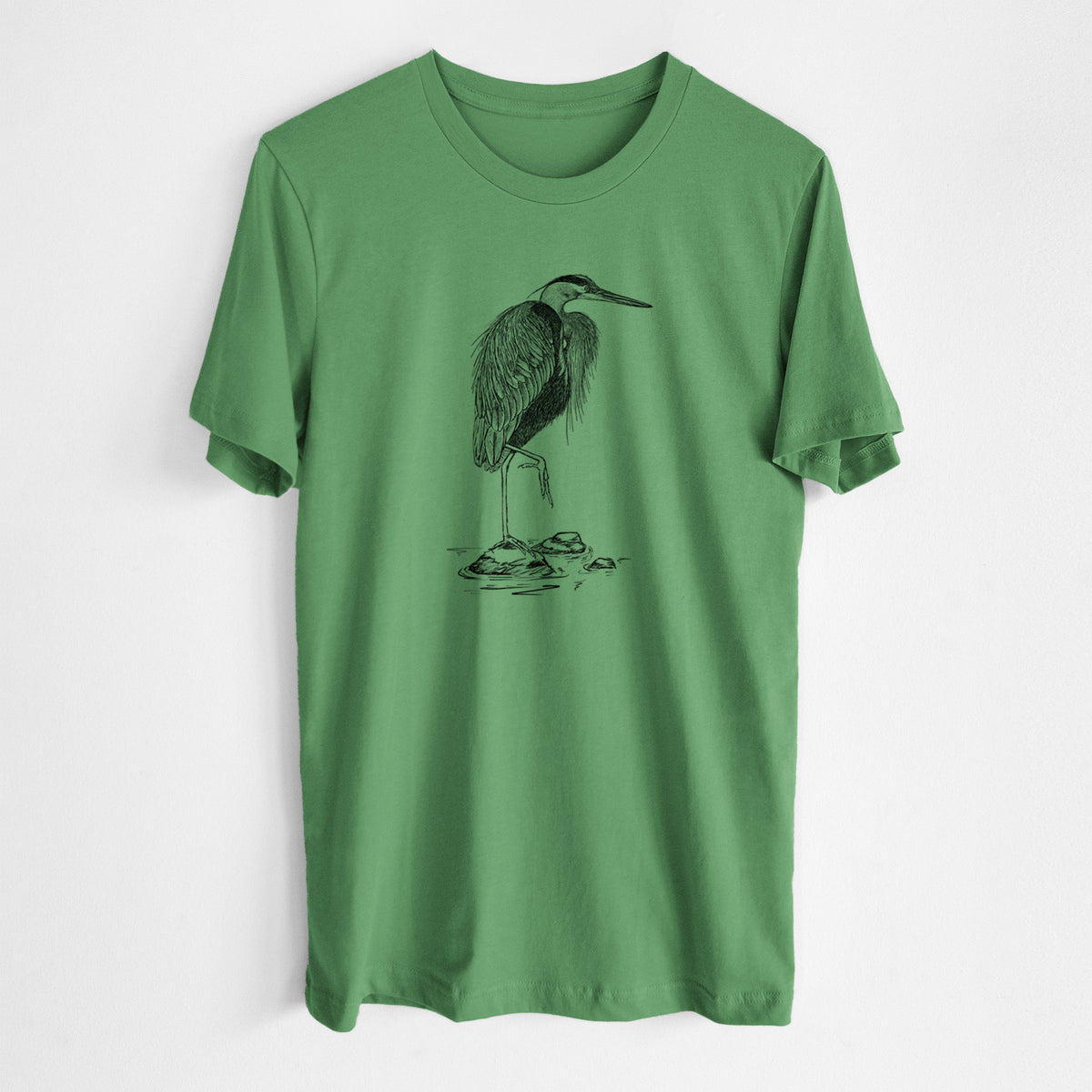 Leaf green lightweight cotton t-shirt laid flat, printed with a detailed black ink illustration of a great blue heron standing on rocks.