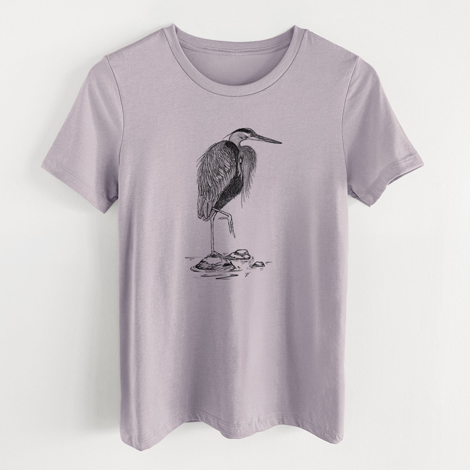 Light violet women's relaxed fit cotton t-shirt laid flat, printed with a detailed black ink illustration of a great blue heron standing on rocks.