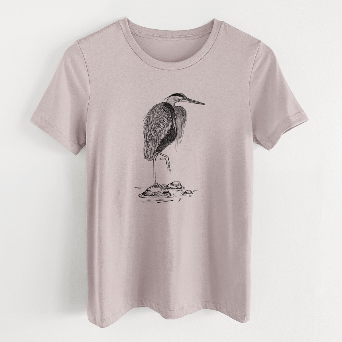 Pink gravel women's relaxed fit cotton t-shirt laid flat, printed with a detailed black ink illustration of a great blue heron standing on rocks.