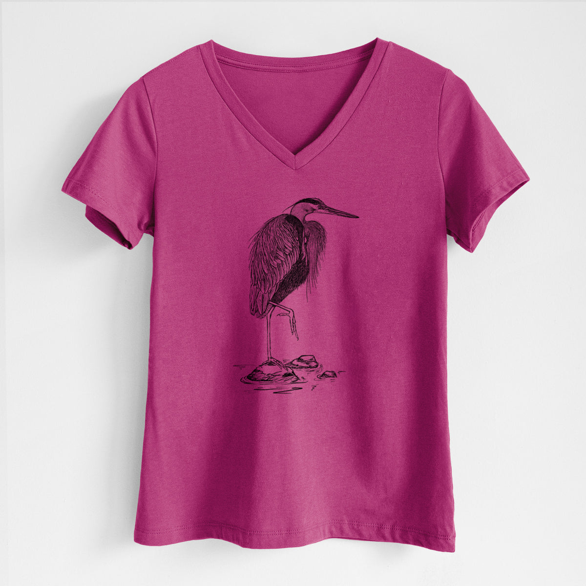 Berry pink women's relaxed fit cotton V-neck t-shirt laid flat, printed with a detailed black ink illustration of a great blue heron standing on rocks.