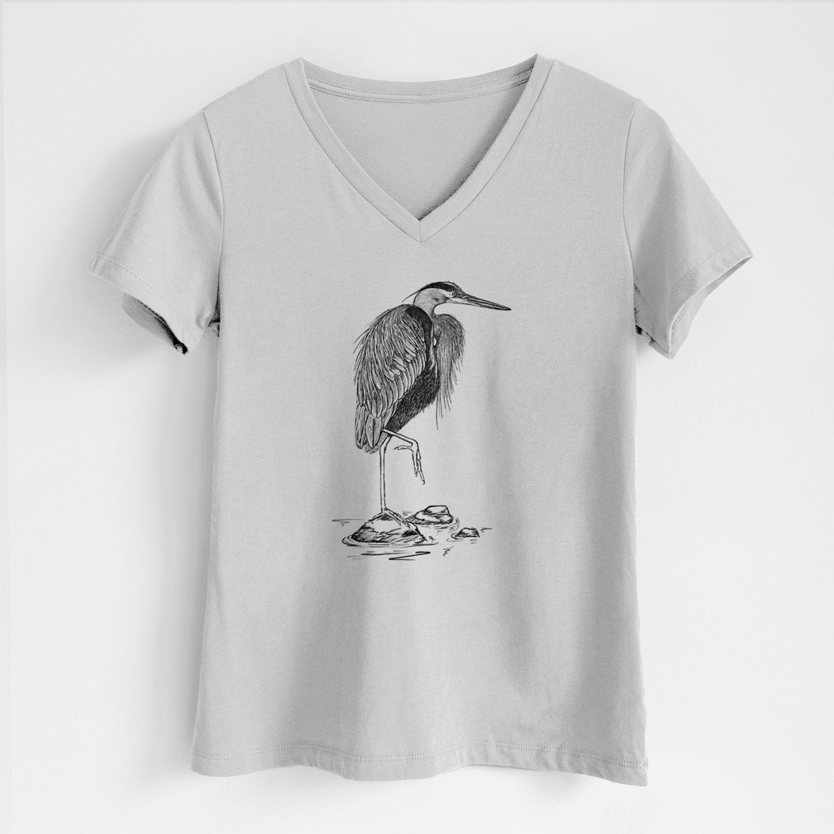 Lunar grey women's relaxed fit cotton V-neck t-shirt laid flat, printed with a detailed black ink illustration of a great blue heron standing on rocks.