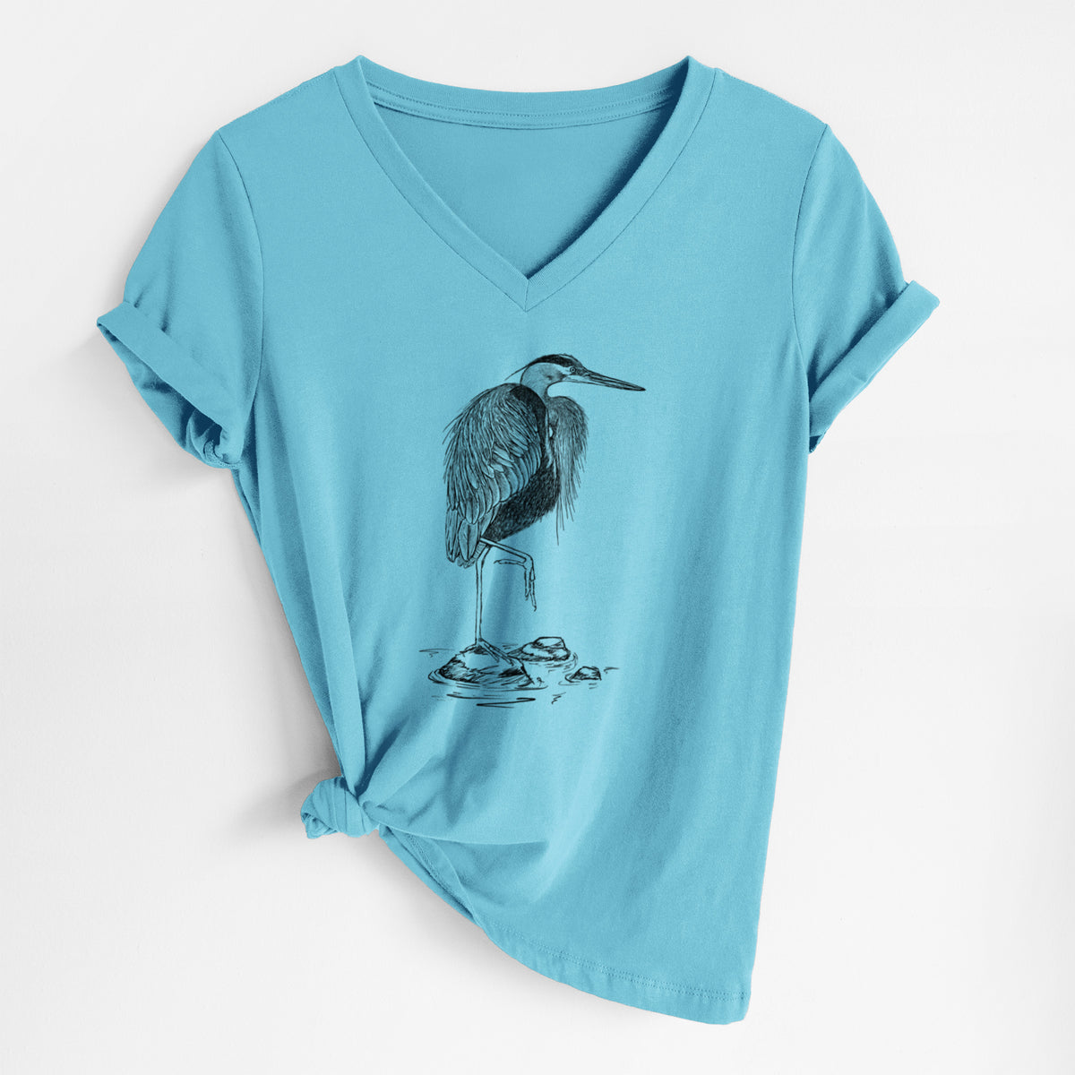 Turquoise women's relaxed fit cotton V-neck t-shirt laid flat, printed with a detailed black ink illustration of a great blue heron standing on rocks.