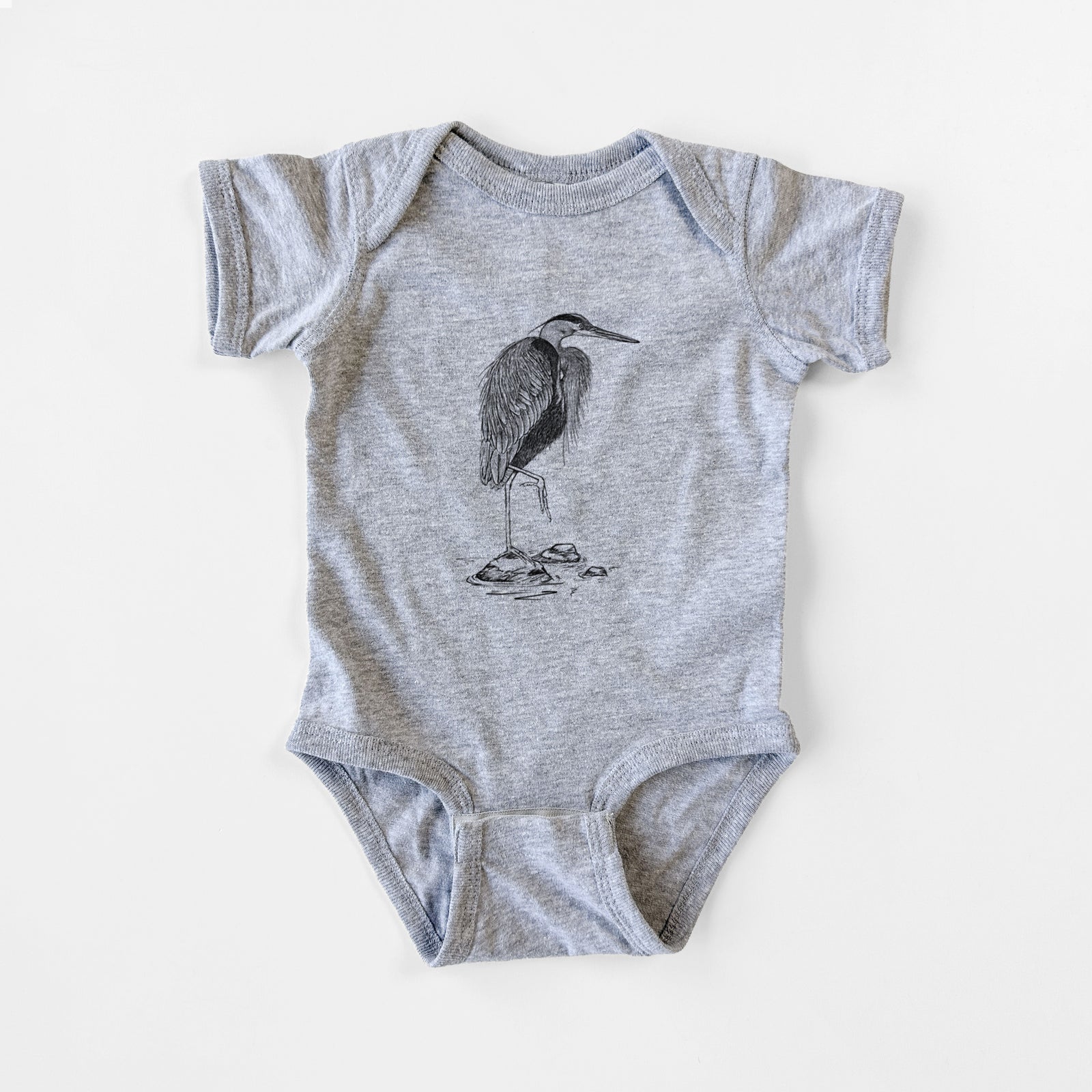 Grey baby bodysuit laid flat, printed with a detailed black ink illustration of a great blue heron standing on rocks.