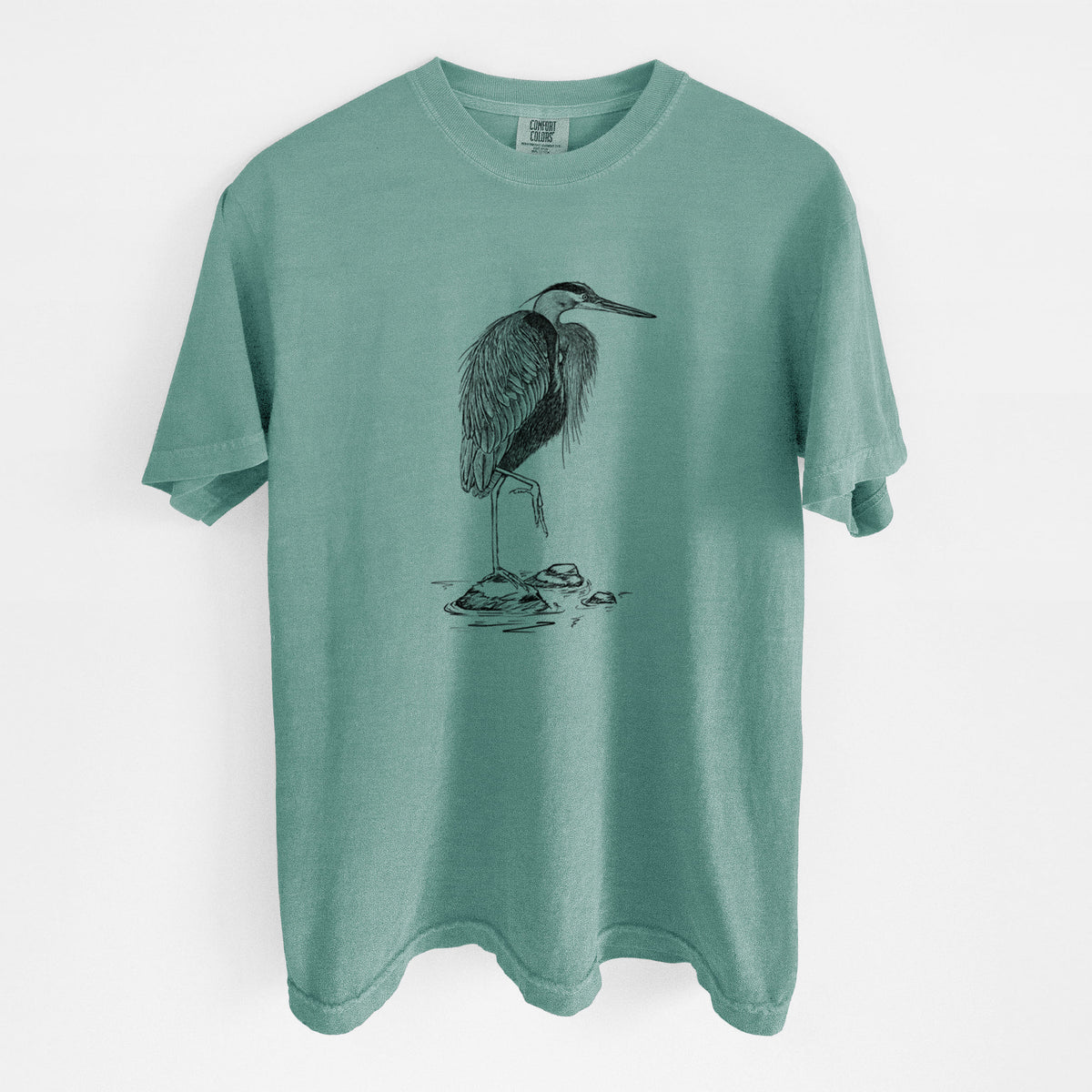 Reef green Comfort Colors t-shirt laid flat, printed with a detailed black ink illustration of a great blue heron standing on rocks.