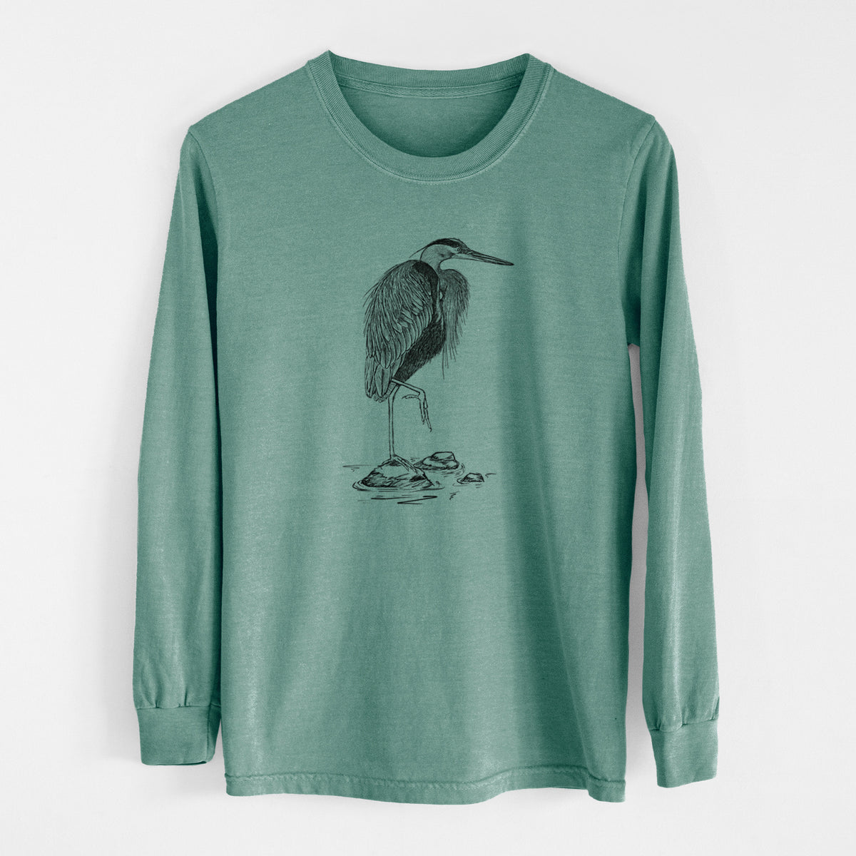 Pine green Comfort Colors long sleeve shirt laid flat, printed with a detailed black ink illustration of a great blue heron standing on rocks.