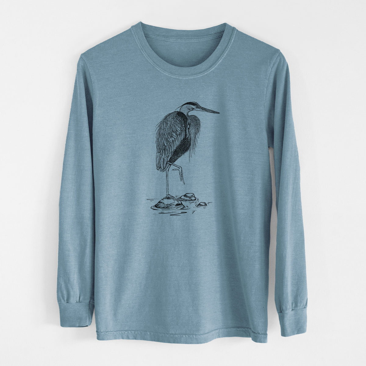 Steel blue Comfort Colors long sleeve shirt laid flat, printed with a detailed black ink illustration of a great blue heron standing on rocks.