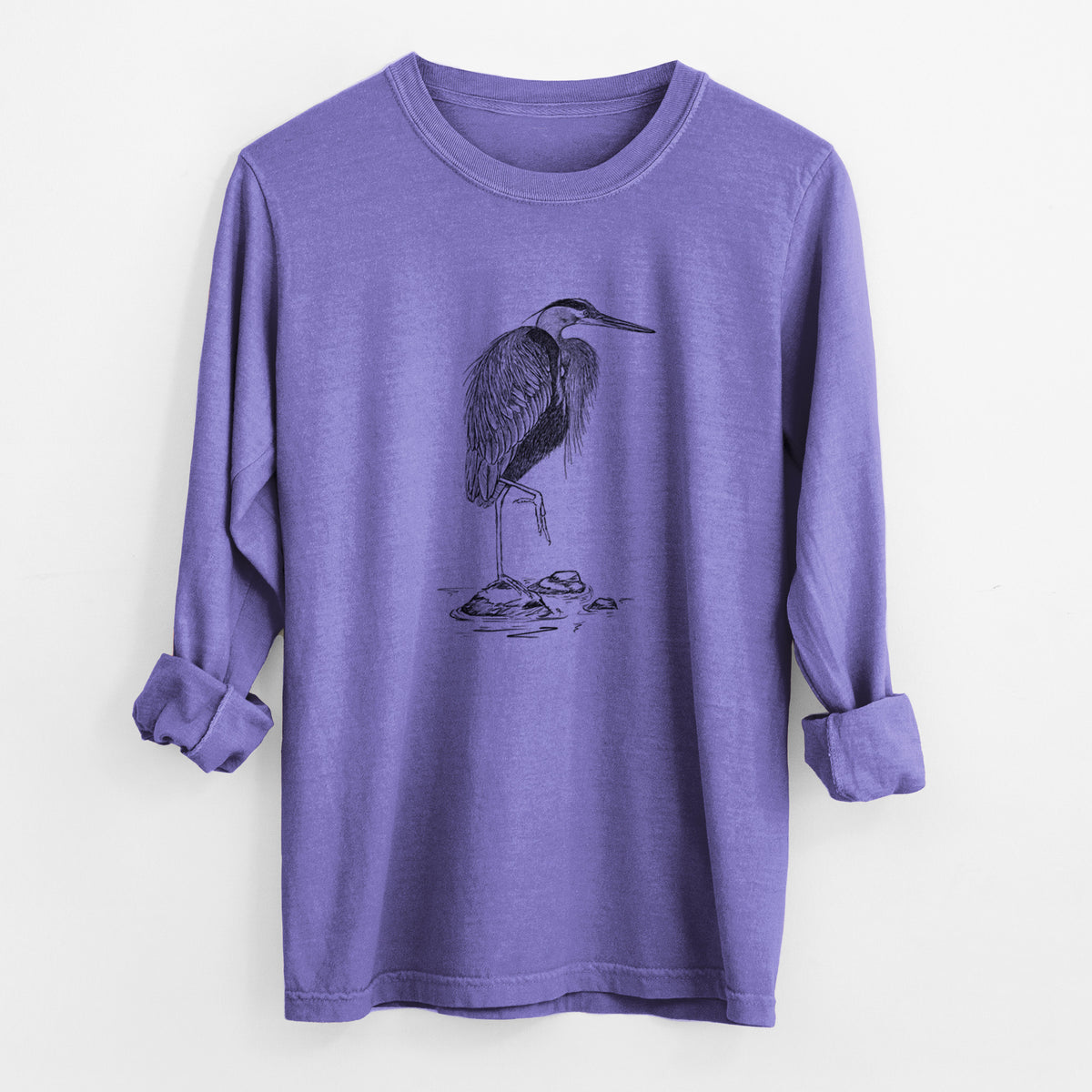 Violet purple Comfort Colors long sleeve shirt laid flat with the cuffs rolled, printed with a detailed black ink illustration of a great blue heron standing on rocks.