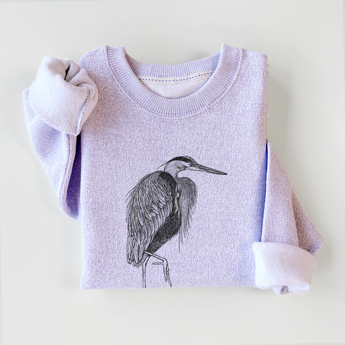 Ice purple knit sweatshirt printed with a detailed black ink illustration of a great blue heron standing on rocks, styled flat.