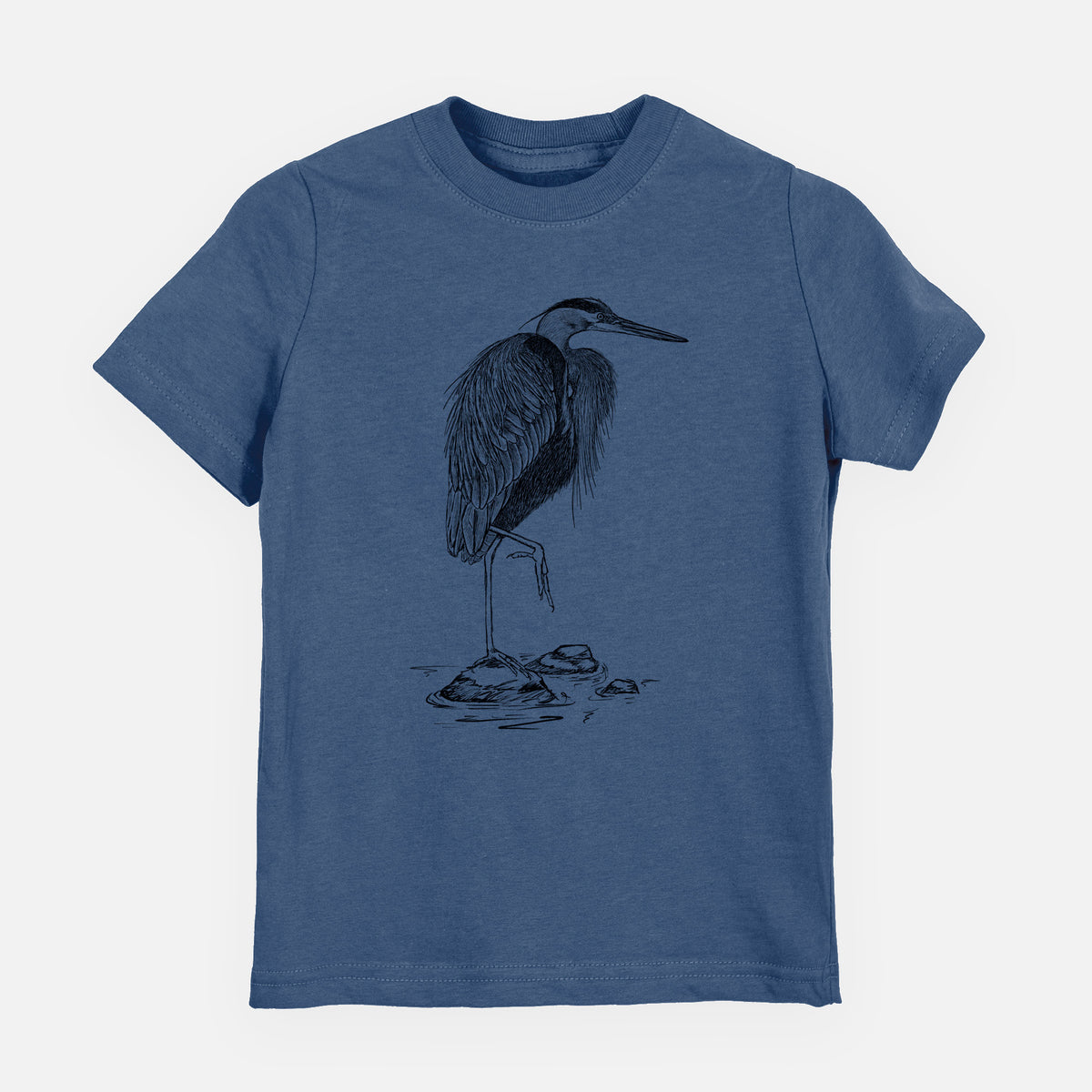 Indigo blue youth t-shirt laid flat, printed with a detailed black ink illustration of a great blue heron standing on rocks.
