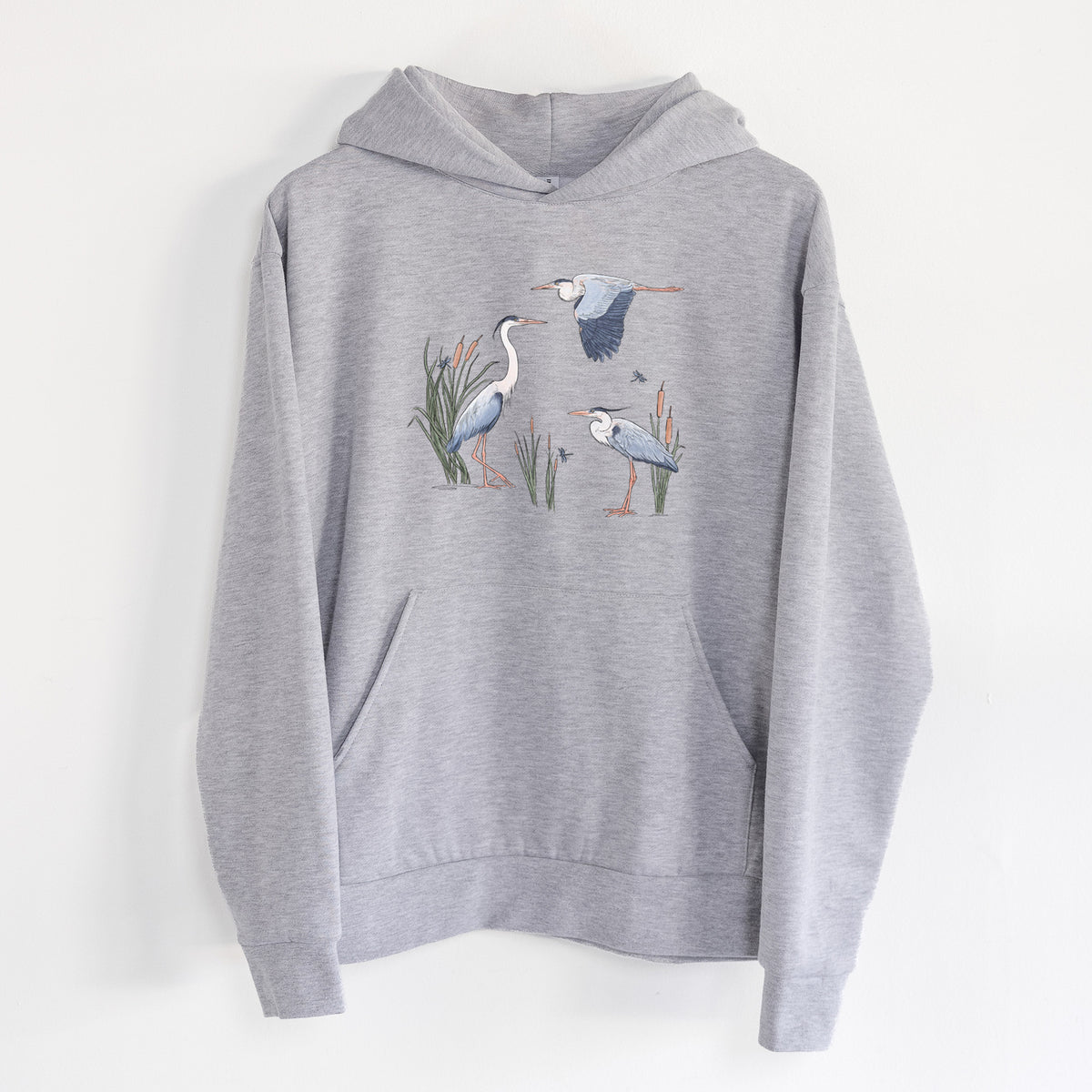 Great Blue Herons in the Cattails - Statement Midweight Hoodie in Heather Grey, hanging on a white wall, with a front kangaroo pocket and no drawcords.