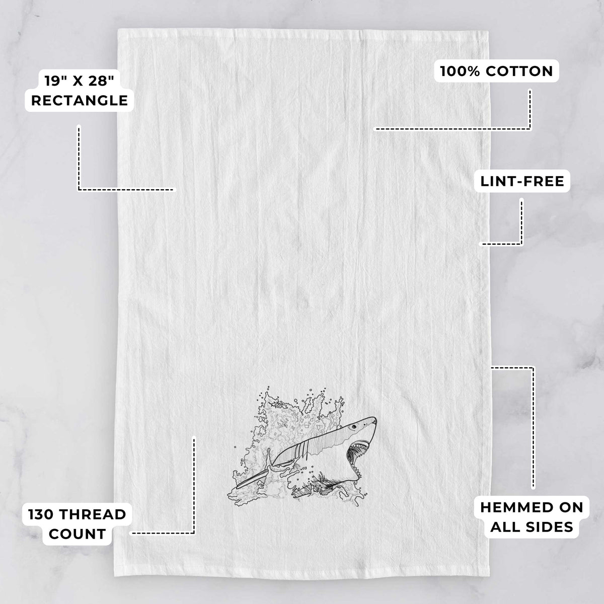 White tea towel printed with a black ink illustration of a great white shark breaking through a splash of water, with feature labels: 19 by 28 inch rectangle, 100% cotton, lint-free, 130 thread count, hemmed on all sides.