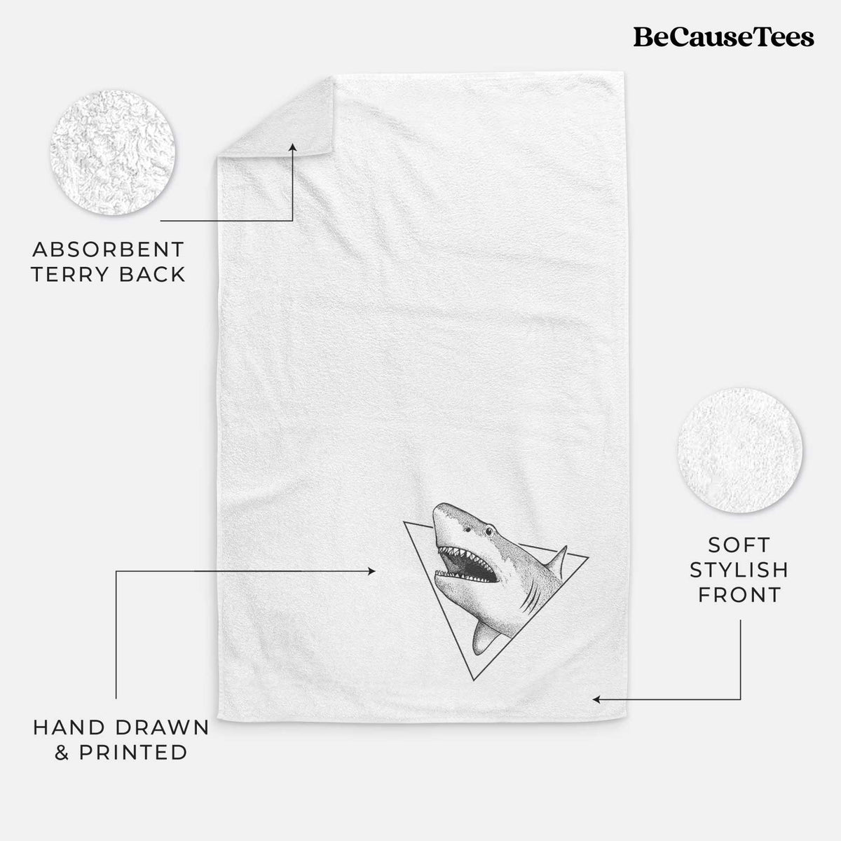 White hand towel printed with a black ink great white shark bursting out of a triangle outline with its mouth open.
