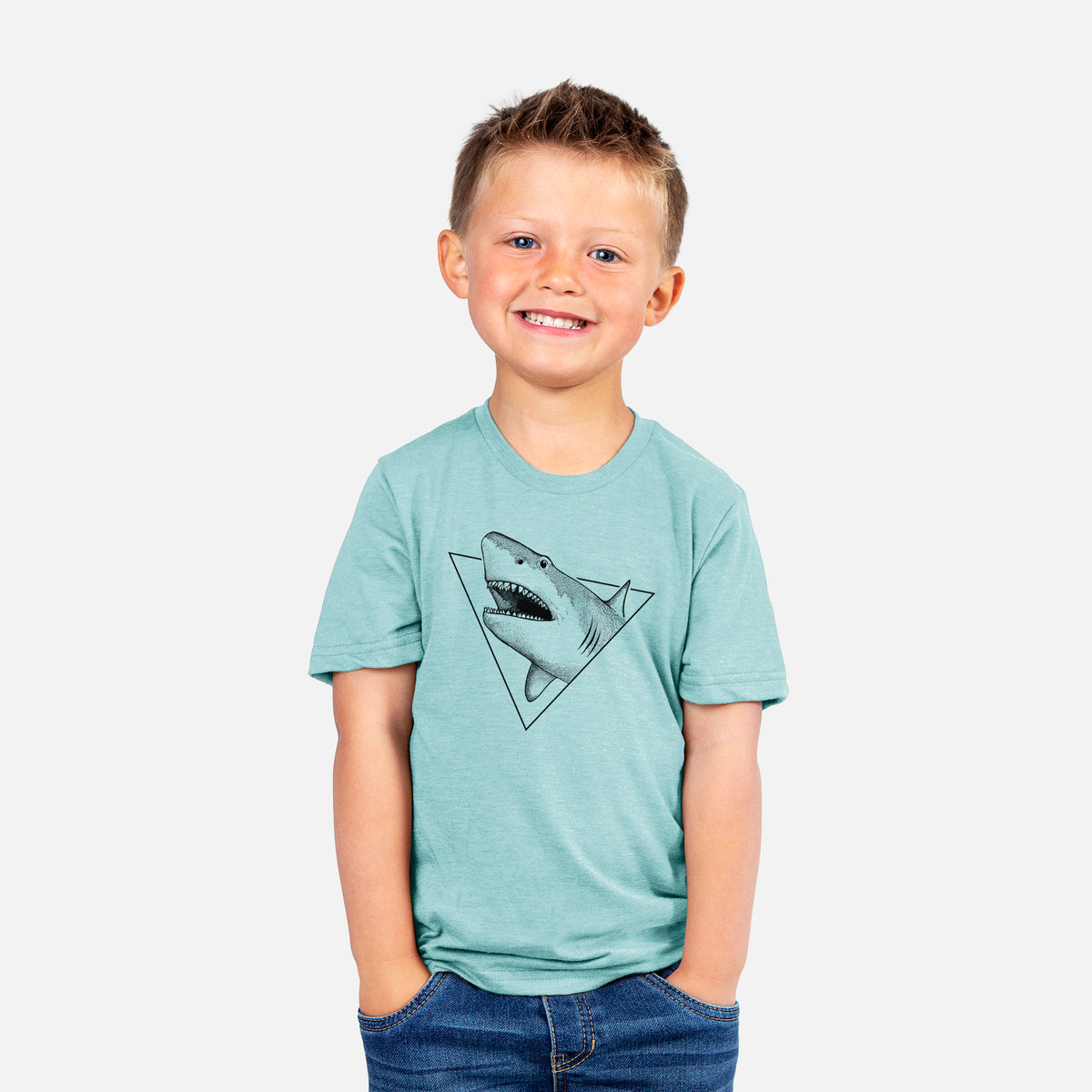 Smiling boy wearing a youth t-shirt printed with a black ink great white shark bursting out of a triangle outline with its mouth open.