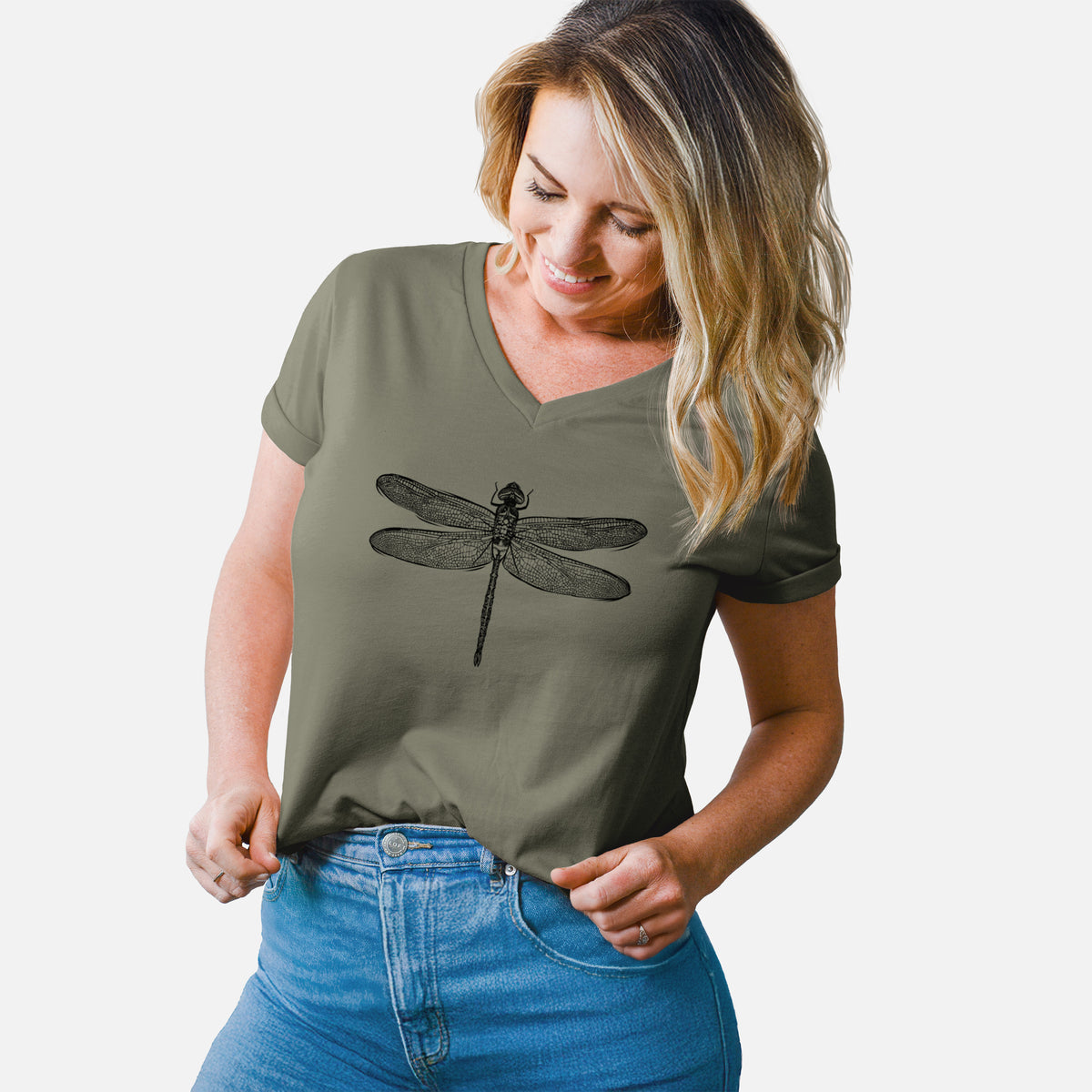 Woman wearing a military green women's relaxed fit cotton V-neck t-shirt printed with a detailed black ink illustration of a green darner dragonfly with its wings spread, seen from above.