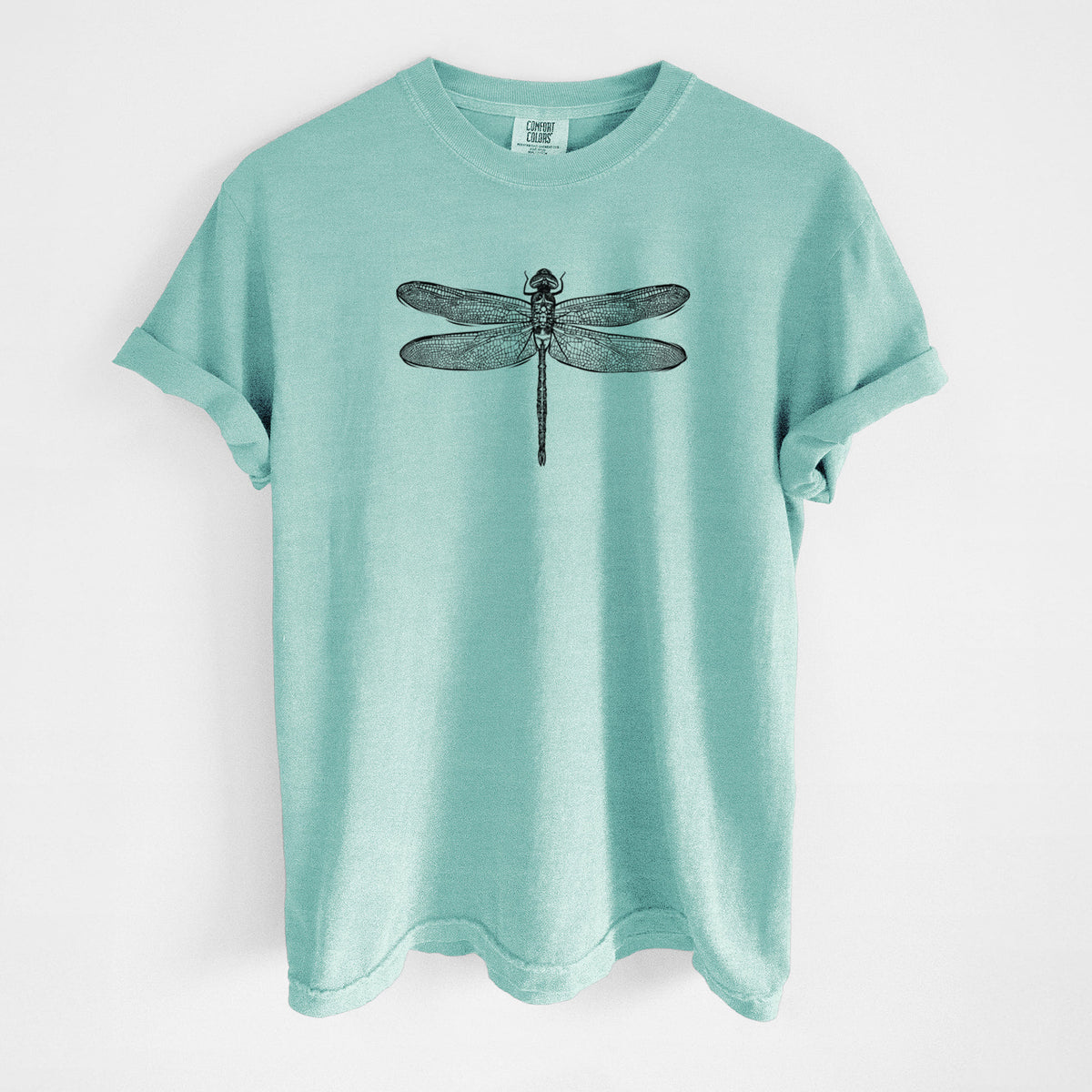 Chalky mint Comfort Colors t-shirt laid flat, printed with a detailed black ink illustration of a green darner dragonfly with its wings spread, seen from above.