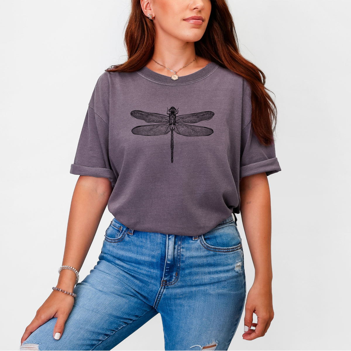 Woman wearing a Comfort Colors t-shirt printed with a detailed black ink illustration of a green darner dragonfly with its wings spread, seen from above.