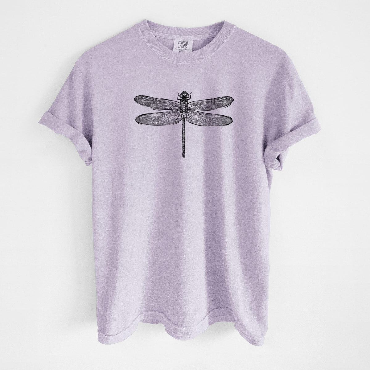 Orchid purple Comfort Colors t-shirt laid flat, printed with a detailed black ink illustration of a green darner dragonfly with its wings spread, seen from above.