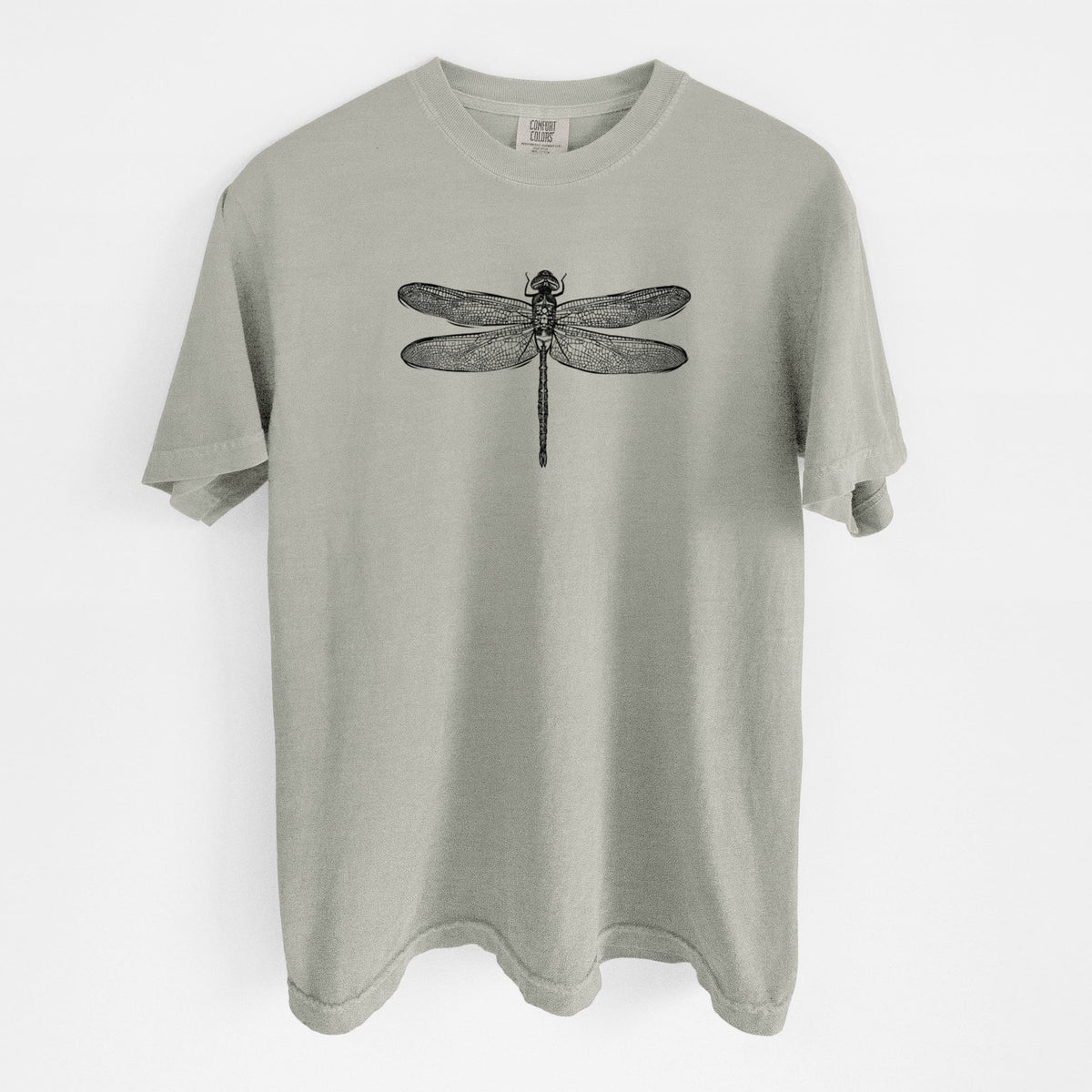 Sandstone beige Comfort Colors t-shirt laid flat, printed with a detailed black ink illustration of a green darner dragonfly with its wings spread, seen from above.