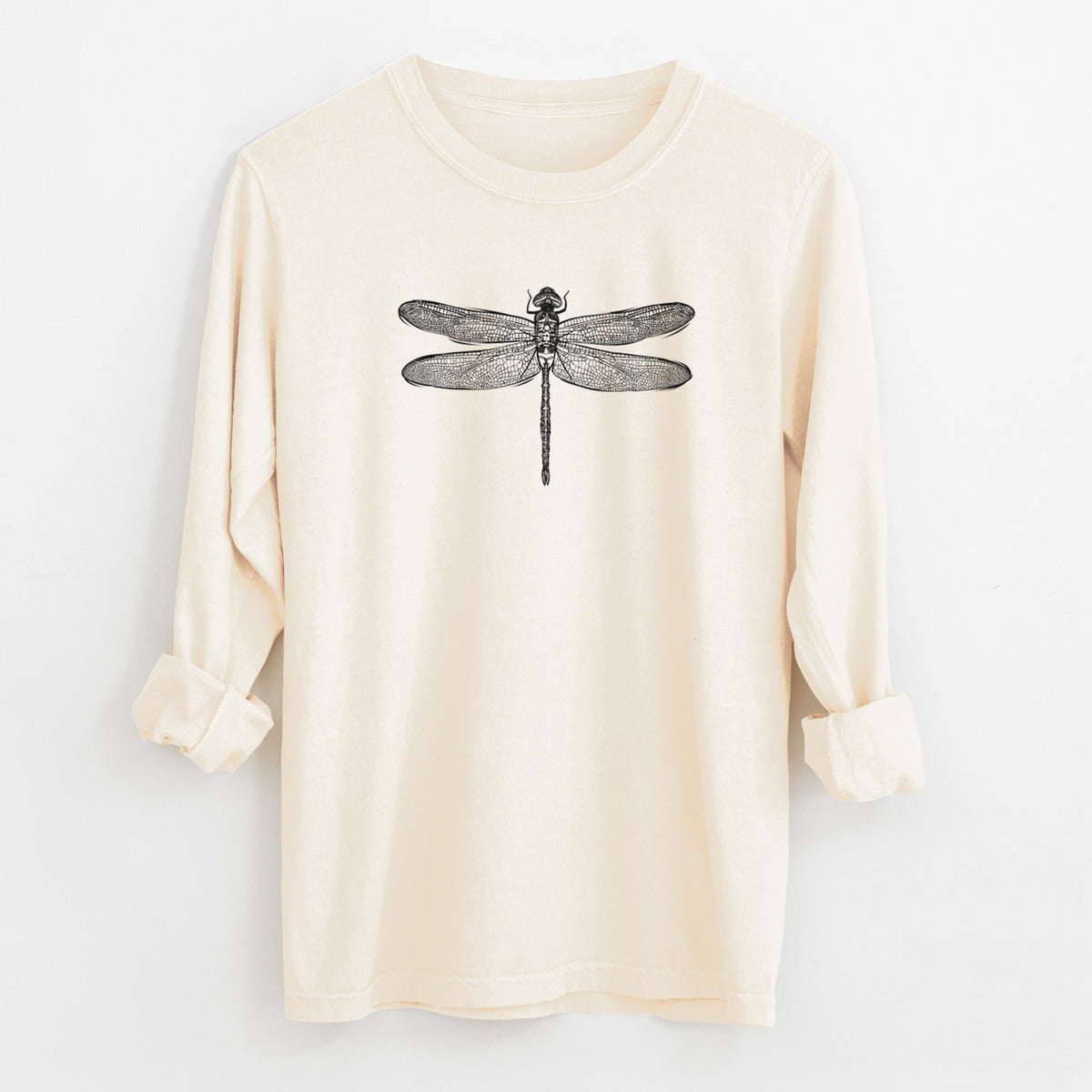 Ivory Comfort Colors long sleeve shirt laid flat with the cuffs rolled, printed with a detailed black ink illustration of a green darner dragonfly with its wings spread, seen from above.